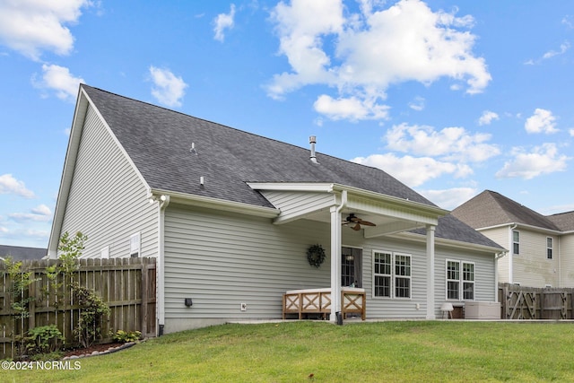 rear view of house featuring a yard and ceiling fan