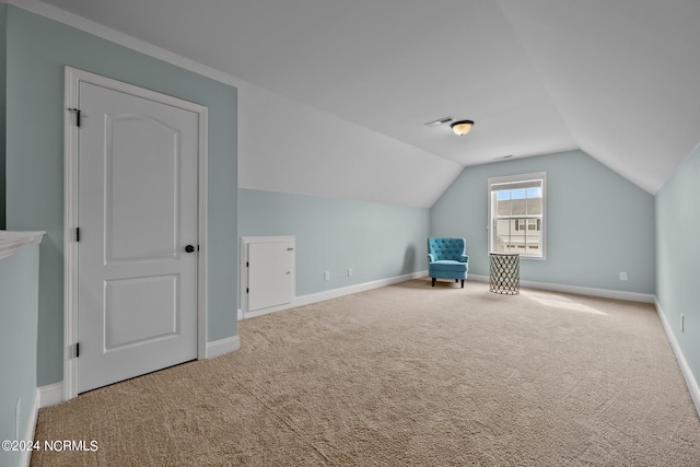 bonus room with lofted ceiling and carpet flooring