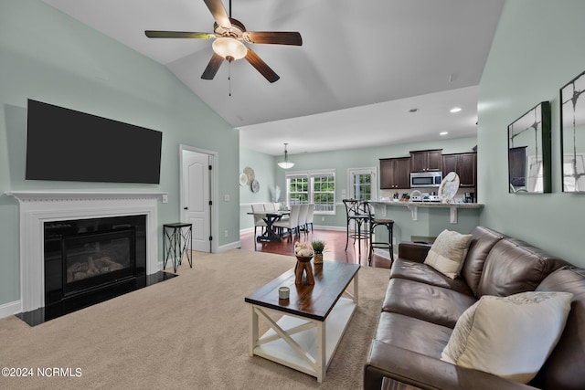 living room featuring light carpet, ceiling fan, and vaulted ceiling