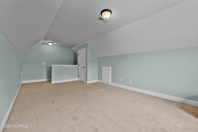 additional living space featuring lofted ceiling and carpet