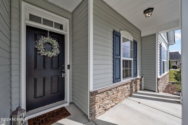 view of exterior entry featuring covered porch