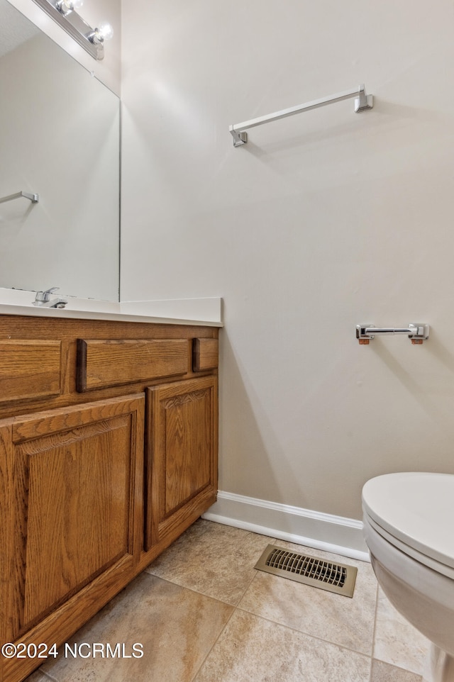 bathroom featuring toilet, vanity, and tile patterned flooring