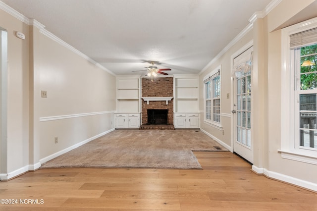 unfurnished living room featuring light hardwood / wood-style flooring, ornamental molding, ceiling fan, and a brick fireplace