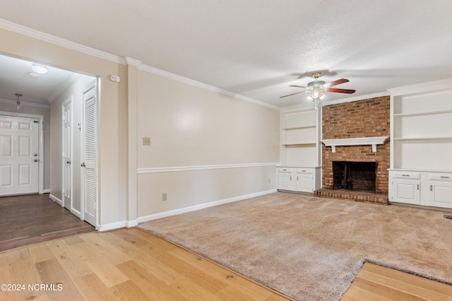 unfurnished living room with hardwood / wood-style flooring, crown molding, a textured ceiling, a fireplace, and ceiling fan