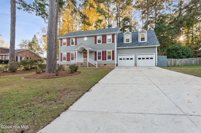 colonial house featuring a front yard and a garage