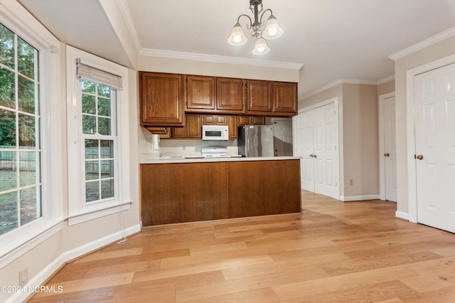 kitchen featuring stainless steel refrigerator, light wood-type flooring, and hanging light fixtures