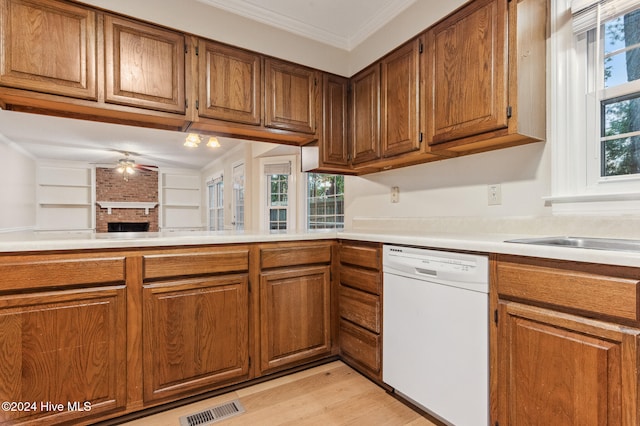 kitchen featuring dishwasher, crown molding, a fireplace, light hardwood / wood-style floors, and ceiling fan