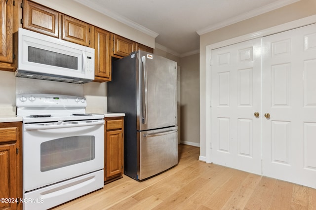 kitchen with white appliances, crown molding, and light wood-type flooring