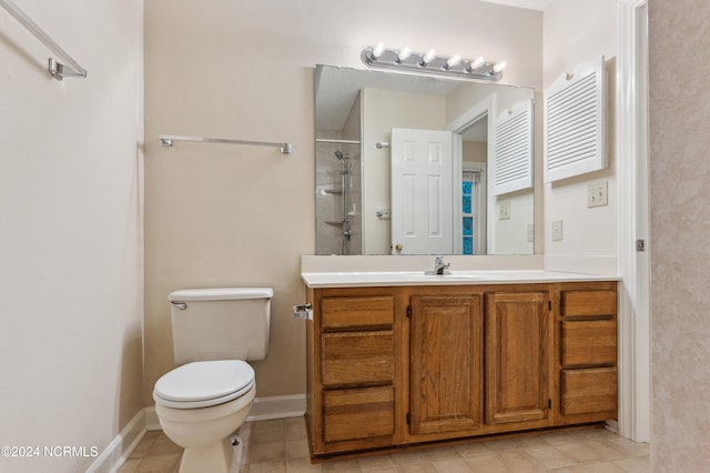 bathroom with toilet, vanity, tile patterned floors, and tiled shower