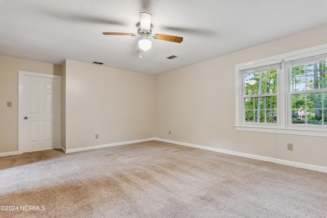 carpeted empty room with a textured ceiling and ceiling fan