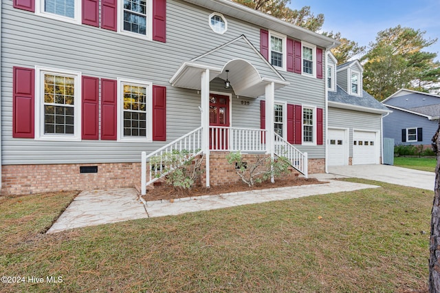 view of front of home featuring a front yard, covered porch, and a garage