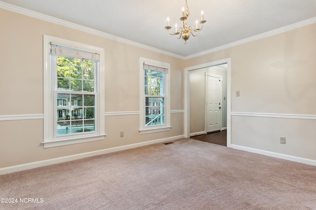 carpeted spare room with ornamental molding, a textured ceiling, and an inviting chandelier