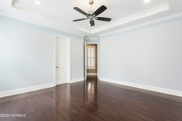 unfurnished room with a raised ceiling, dark hardwood / wood-style flooring, and ceiling fan