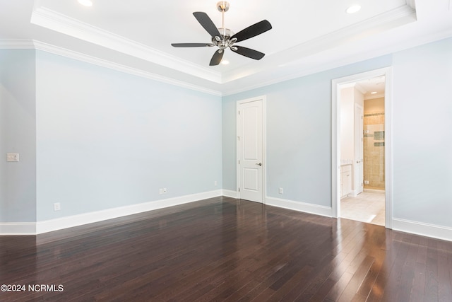 empty room featuring wood-type flooring, a tray ceiling, and ornamental molding