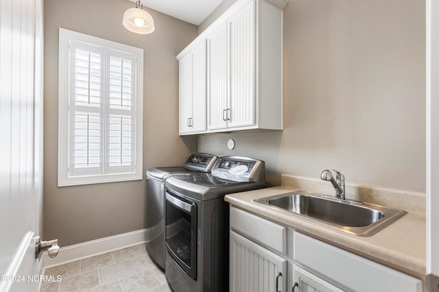 laundry area featuring cabinets, sink, washer and dryer, and light tile patterned flooring