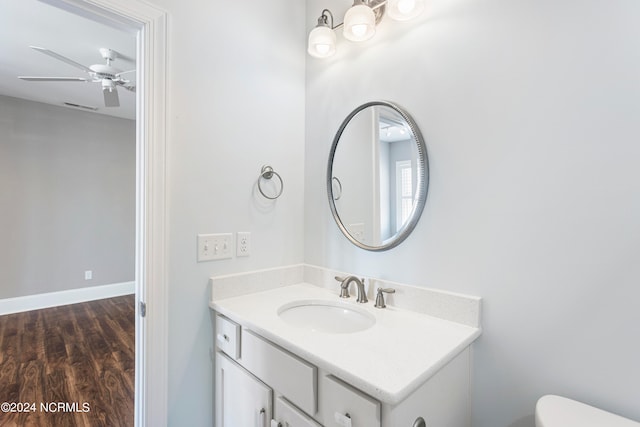 bathroom with hardwood / wood-style flooring, toilet, and vanity