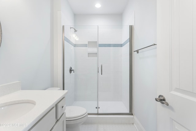 bathroom featuring vanity, toilet, an enclosed shower, and tile patterned floors