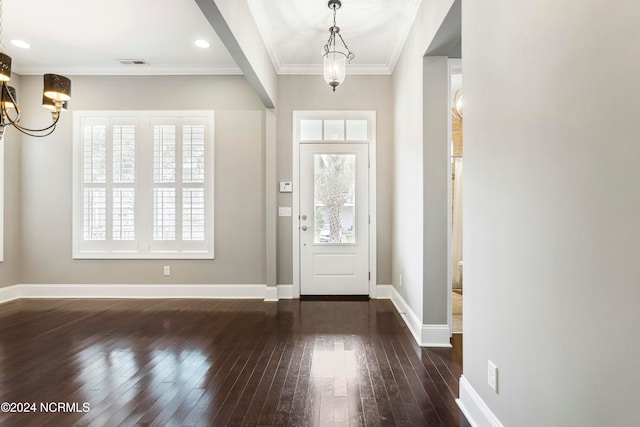 entryway featuring ornamental molding, a notable chandelier, and dark hardwood / wood-style flooring