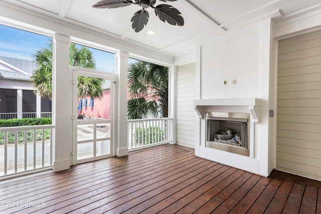 unfurnished sunroom with ceiling fan