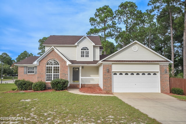 view of property featuring a front lawn, covered porch, and a garage