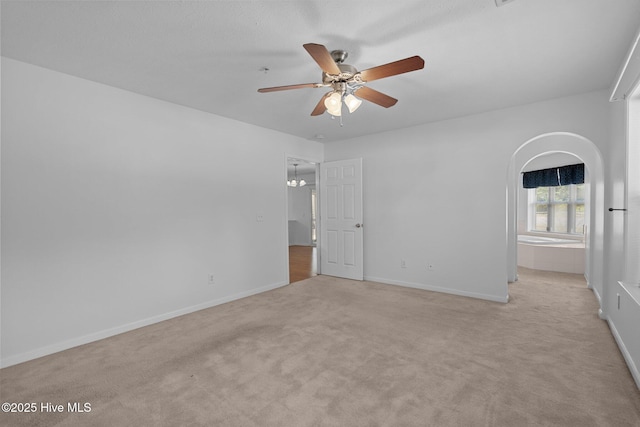 633 Spencer Farlow Dr Unit 12, Carolina Beach, NC 28428 - unfurnished bedroom with light carpet, baseboards, ceiling fan, and arched walkways