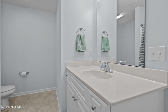 bathroom featuring vanity, tile patterned flooring, and toilet