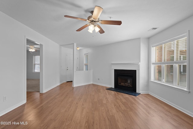 633 Spencer Farlow Dr Unit 12, Carolina Beach, NC 28428 - unfurnished living room with a ceiling fan, healthy amount of natural light, and a glass covered fireplace