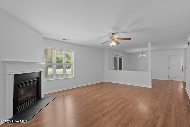 633 Spencer Farlow Dr Unit 12, Carolina Beach, NC 28428 - unfurnished living room with a glass covered fireplace, a ceiling fan, wood finished floors, and baseboards