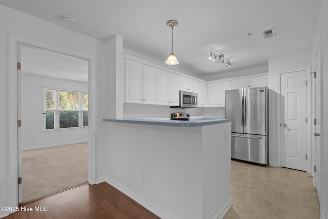 633 Spencer Farlow Dr Unit 12, Carolina Beach, NC 28428 - kitchen featuring appliances with stainless steel finishes, white cabinetry, pendant lighting, baseboards, and a peninsula