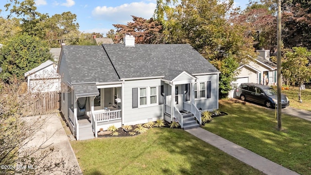 bungalow with covered porch and a front lawn