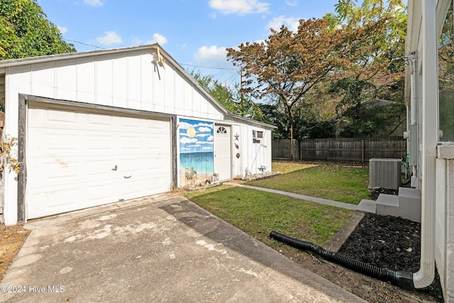 garage featuring central air condition unit and a lawn