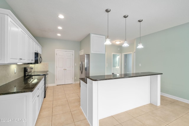 499 Ward Rd, Swansboro, NC 28584 - kitchen with white cabinets, backsplash, black microwave, stainless steel fridge, and electric range