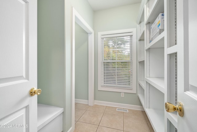 walk in closet with light tile patterned floors