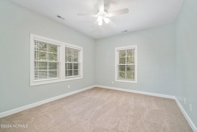 carpeted spare room with ceiling fan