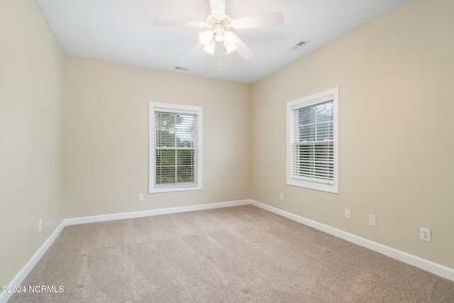 carpeted empty room featuring ceiling fan and plenty of natural light