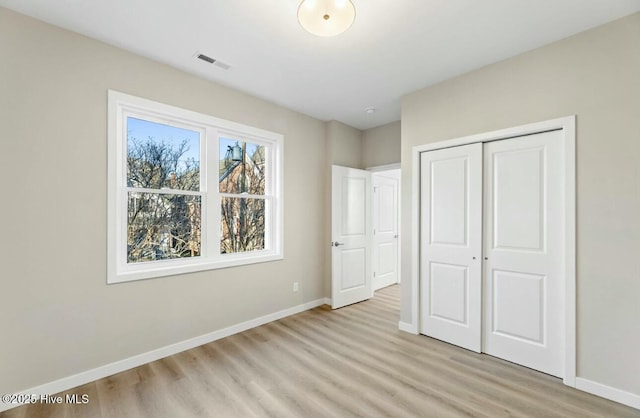 unfurnished bedroom featuring light hardwood / wood-style flooring and a closet