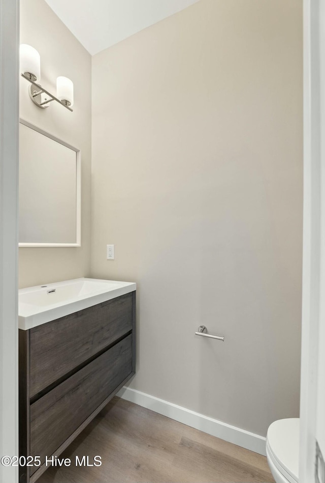 bathroom featuring hardwood / wood-style floors, vanity, and toilet