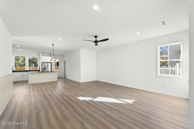 unfurnished living room with light wood-type flooring and ceiling fan