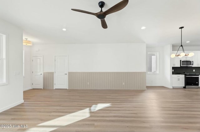 unfurnished living room featuring light wood-type flooring and ceiling fan