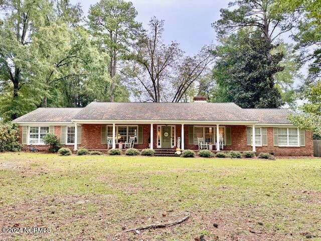 single story home with a porch and a front lawn