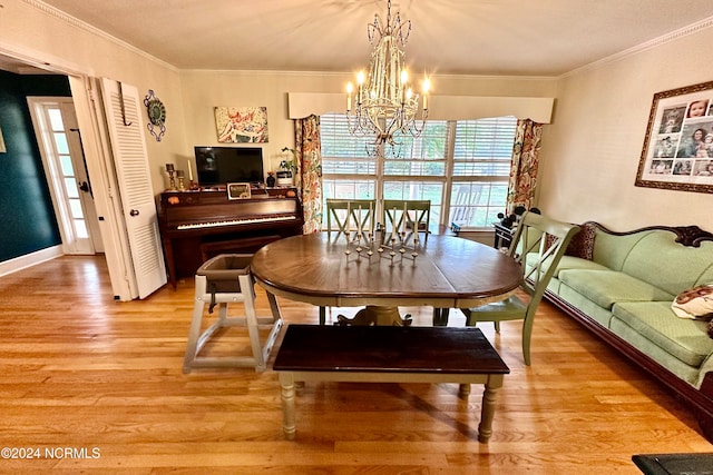 dining area featuring ornamental molding, a notable chandelier, and light hardwood / wood-style floors