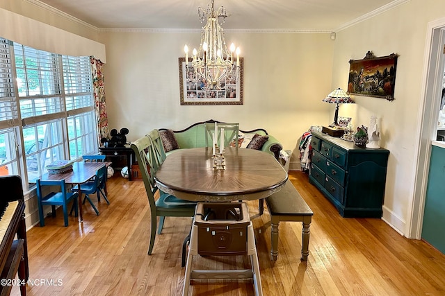 dining area with ornamental molding, an inviting chandelier, and light hardwood / wood-style floors