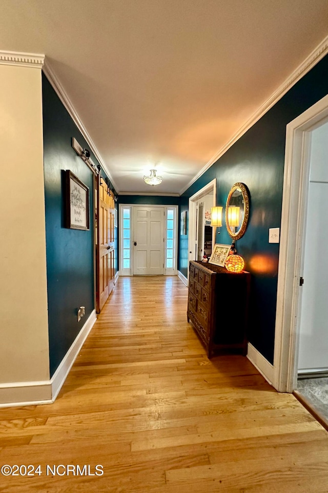 corridor featuring ornamental molding and light hardwood / wood-style flooring