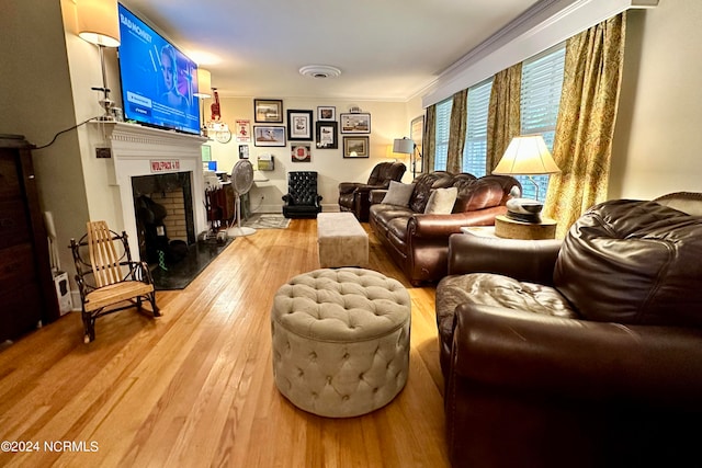 living room featuring crown molding and light hardwood / wood-style flooring