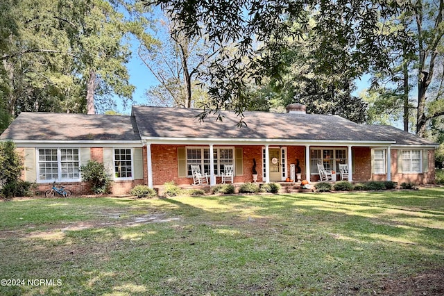 ranch-style house featuring a porch and a front lawn