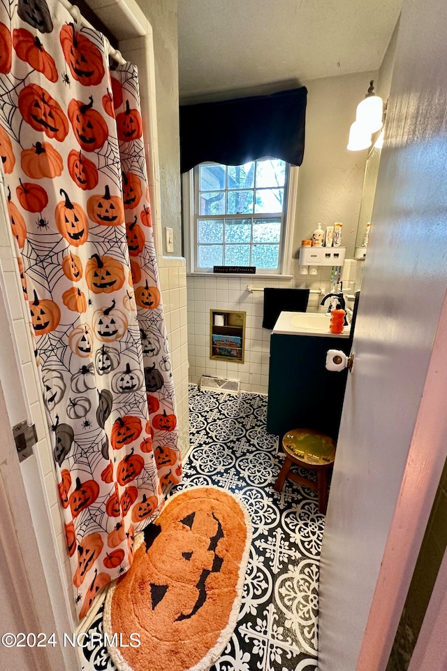 bathroom with a shower with curtain, vanity, tile walls, and tile patterned flooring