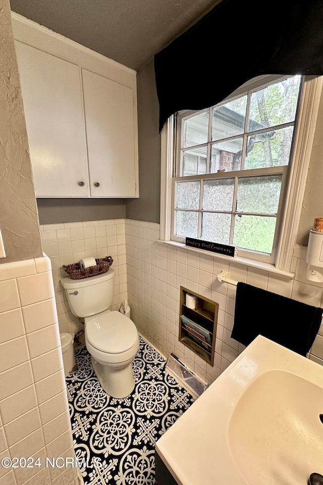 bathroom with tile patterned floors, vanity, tile walls, and toilet