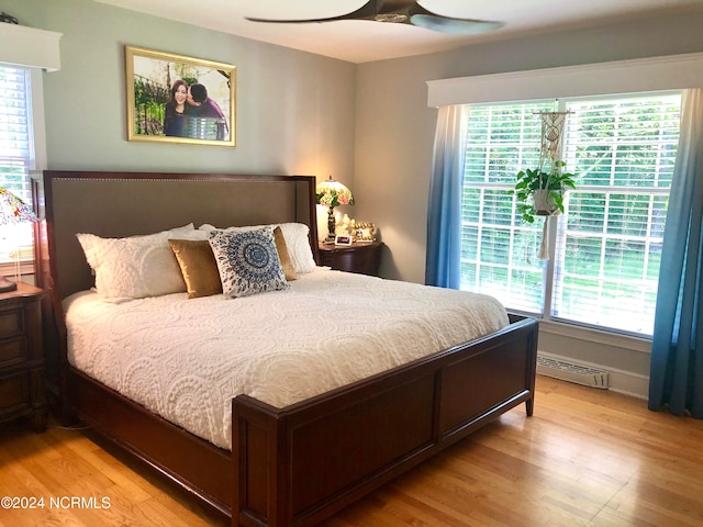 bedroom with multiple windows, ceiling fan, and light hardwood / wood-style floors