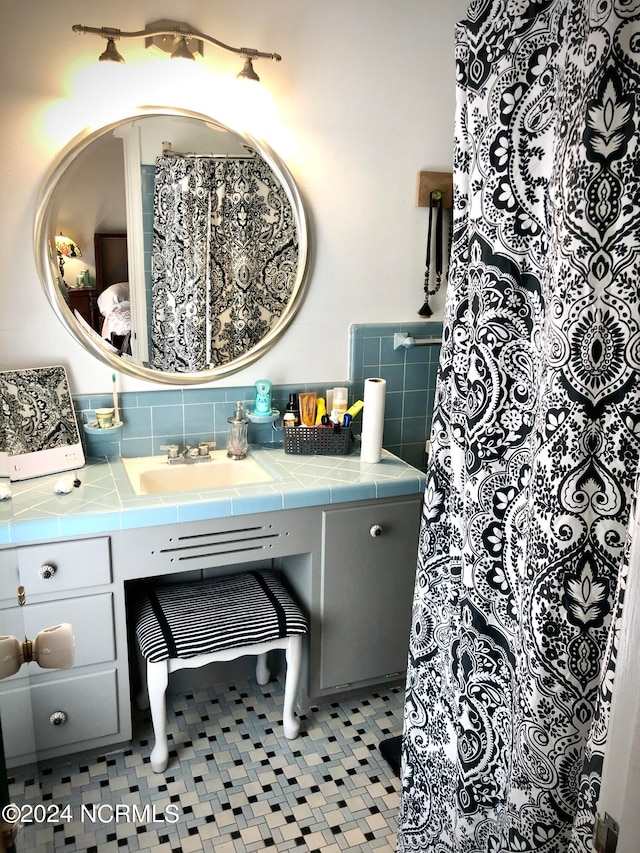 bathroom with tile patterned flooring, vanity, and backsplash