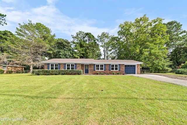 ranch-style house featuring a front lawn and a garage